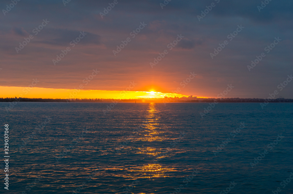 Beautiful colorful tropical sunset with orange sun and blue calm sea