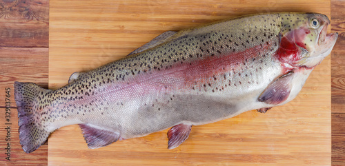 Fresh uncooked rainbow trout on the cutting board
