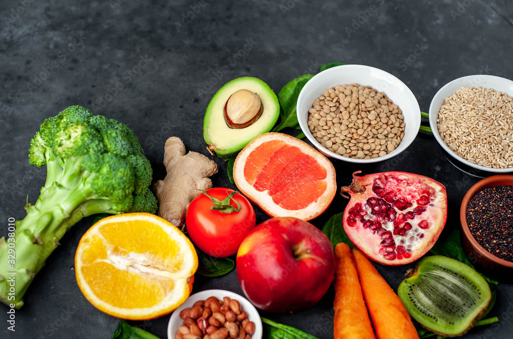 Selection of healthy food: fruits, seeds, cereals, superfoods, vegetables, leafy vegetables on a stone background. Healthy food for humans. Copy space for your text. Selection of healthy food: fruits, seeds, cereals, superfoods, vegetables, leafy vegetables on a stone background. Healthy food for humans. Copy space for your text.
