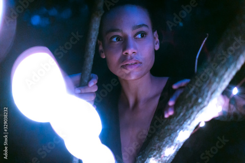 Ritratto di una ragazza mentre tiene delle luci di notte in segno di libertà e relax