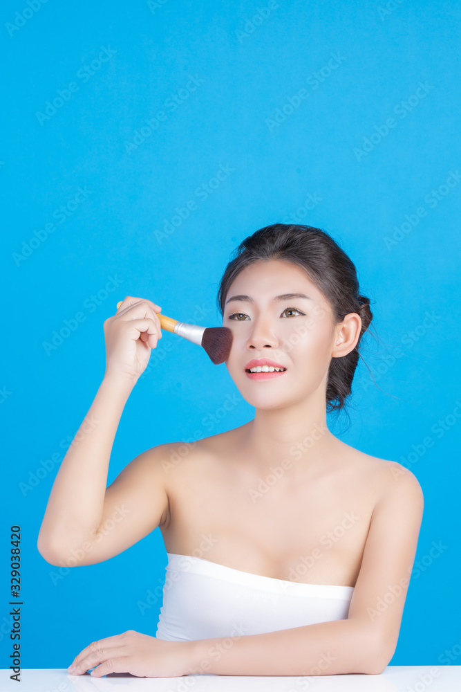 The beauty of women with perfect skin health images Touching her face and smiling like a spa to pamper her skin Blue background The beauty of women with perfect skin health images Touching her face and smiling like a spa to pamper her skin Blue background