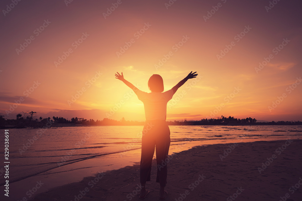 Copy space of woman rise hand up on sunset sky at beach and island background. Copy space of woman rise hand up on sunset sky at beach and island background.