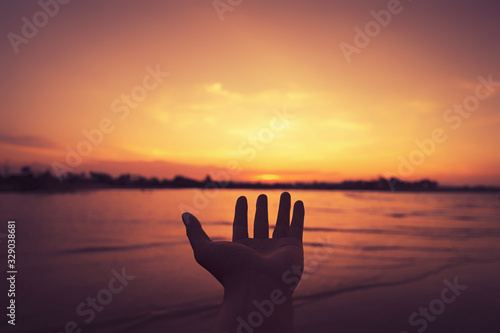Man open hand up on tropical sunset background.