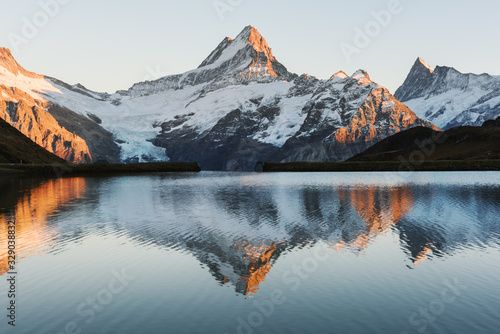 Bachalpsee lake with reflection in Swiss Alps mountains. Glowing snowy peaks on background. Grindelwald valley, Switzerland. Landscape photography © Ivan Kmit