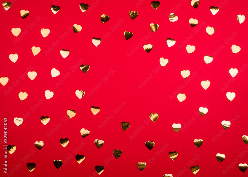 Bright red background with golden candy in the form of small hearts. Bright red background with golden candy in the form of small hearts.