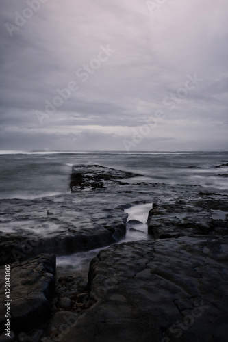 Rocks on the shore of Atlantic ocean in Iceland long exposure