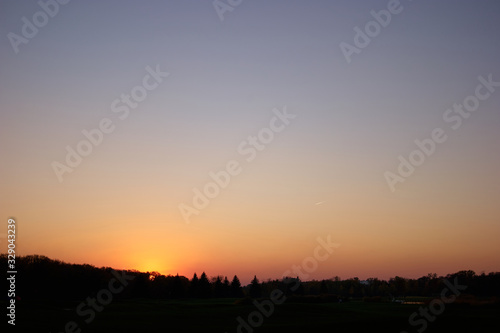 Sundown at horizon. Trees silhouette during evening down.