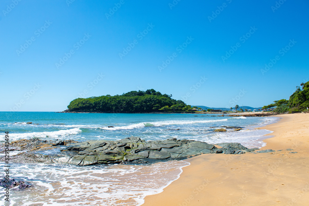 Praia tropical, mar verde da Praia da ilhota ou praia do Plaza, itapema, SC, Brasil ao fundoa Ilha do Pirata