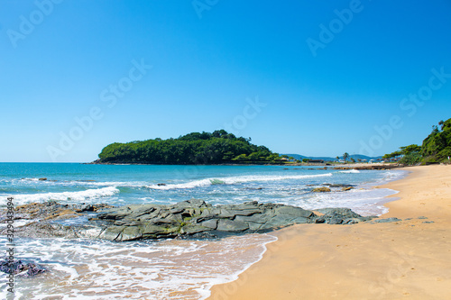 Praia tropical, mar verde da Praia da ilhota ou praia do Plaza, itapema, SC, Brasil ao fundoa Ilha do Pirata photo