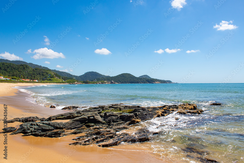 Mar azul esverdeado e pedras de praia tropical< itapema