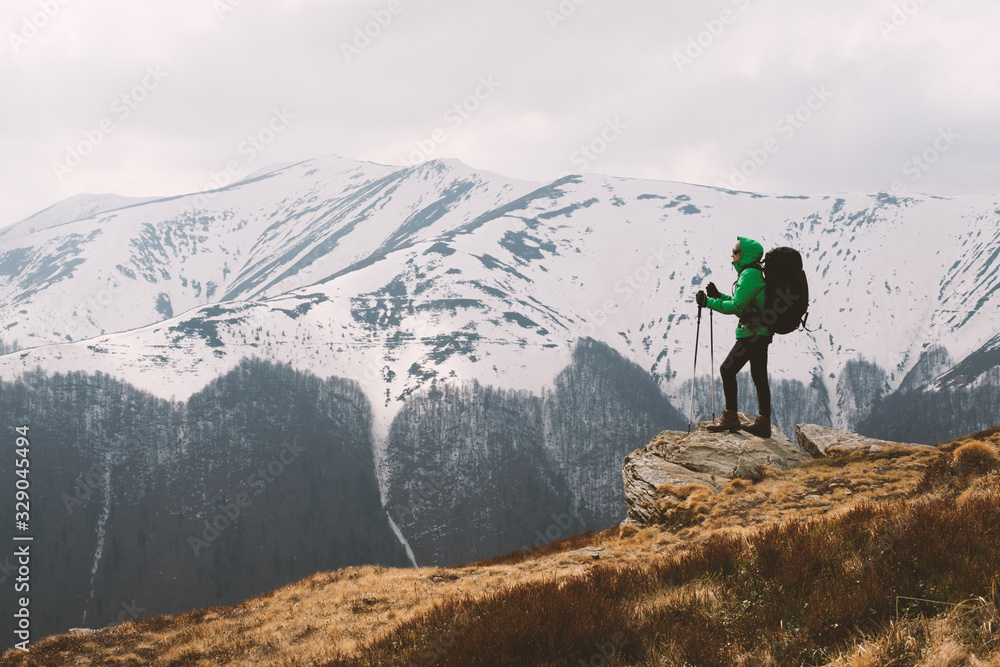 Obraz premium Amazing landscape with snowy mountains range and hiker with backpack on a foreground