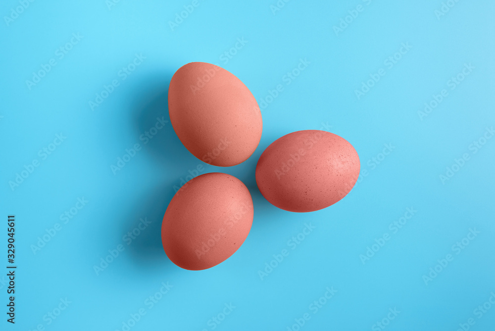 Three red easter eggs on blue surface. Colorful easter eggs decoration. Flat lay, top view. with copy space for text. Three red easter eggs on blue surface. Colorful easter eggs decoration. Flat lay, top view. with copy space for text.