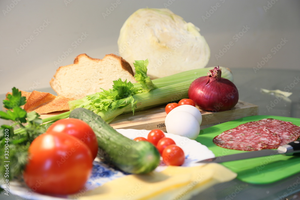 Still life from fresh vegetables and bread: celery, tomatoes, greens, cabbages Still life from fresh vegetables and bread: celery, tomatoes, greens, cabbages