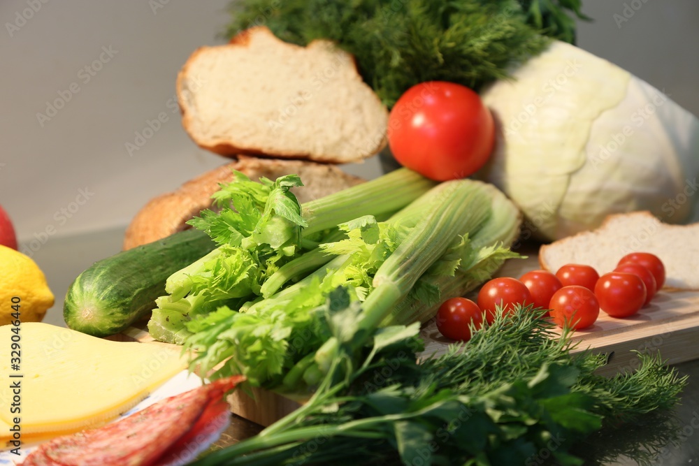 Still life from fresh vegetables and bread: celery, tomatoes, greens, cabbages Still life from fresh vegetables and bread: celery, tomatoes, greens, cabbages