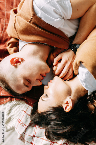 Beautiful couple on the bed. Love story in the interior Studio. Happy and laughing people. At home, having fun on the bed.