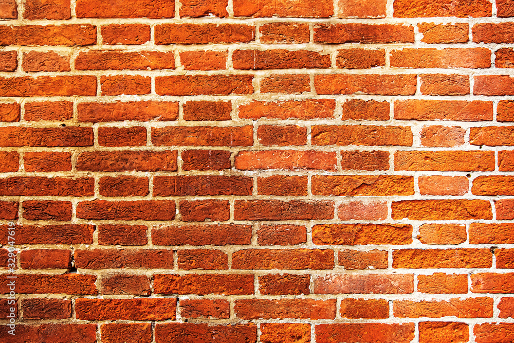 Fototapeta premium Weathered texture of a rough red-brown brick wall