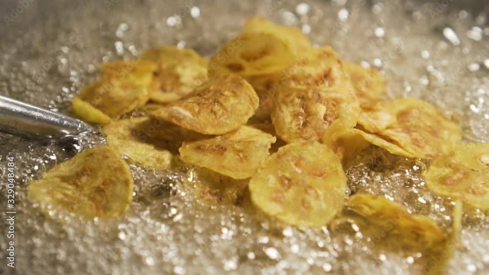Pieces of banana get pouring on a pan full of oil.Making of Sweet Banana Crisp. Thai Dessert. fat. close up. slow motion Pieces of banana get pouring on a pan full of oil.Making of Sweet Banana Crisp. Thai Dessert. fat. close up. slow motion