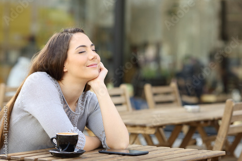 Satisfied girl breathing fresh air on a cafe terrace