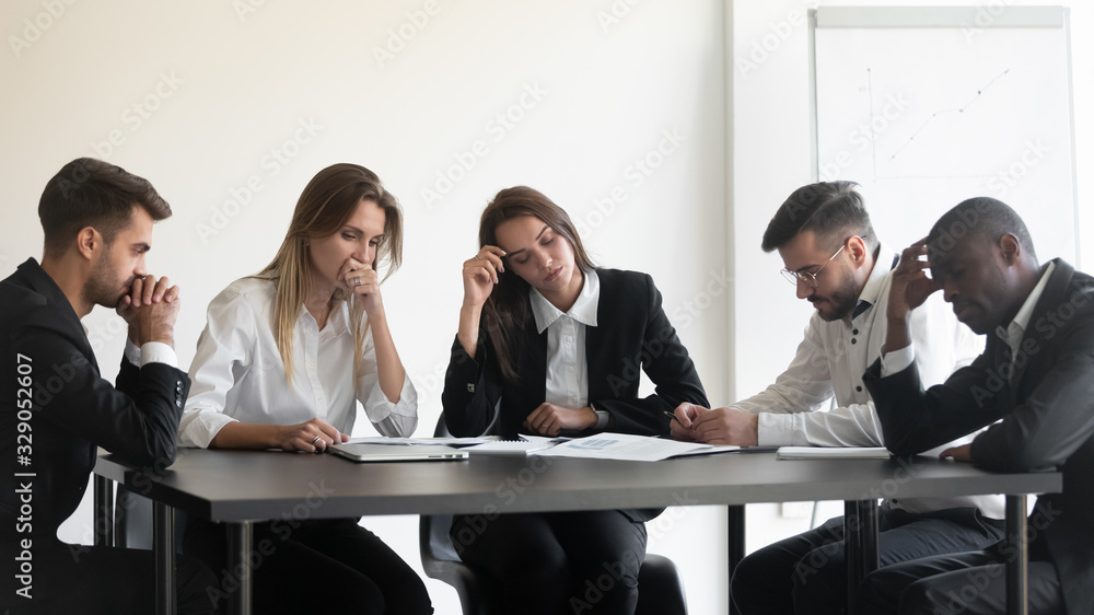 Overworked upset tired group of diverse people sitting at table, dissatisfied with work results. Frustrated female male employees feeling fatigued, worrying about paperwork documents, company crisis. Overworked upset tired group of diverse people sitting at table, dissatisfied with work results. Frustrated female male employees feeling fatigued, worrying about paperwork documents, company crisis.