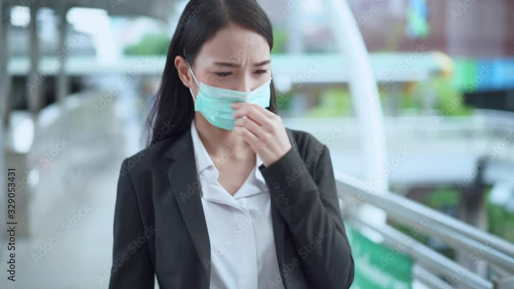 Asian business woman wearing medical mask protection walking in the business district and feeling smell of air polution, virus, covid-19 coronavirus and flu concept. Asian business woman wearing medical mask protection walking in the business district and feeling smell of air polution, virus, covid-19 coronavirus and flu concept.