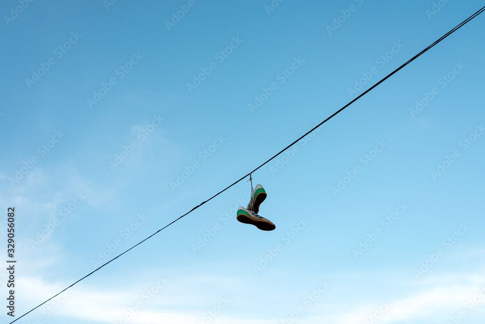 sneakers hung on an electric cable sneakers hung on an electric cable