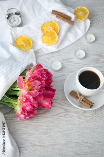 Floral's spring banner. Tulips bouquet and cup of coffee on white background. Flat lay, top view. 