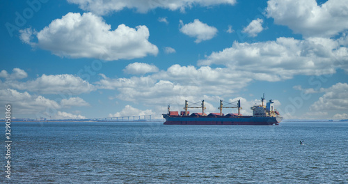 A dredging ship anchored in a harbor and working on the shipping lane