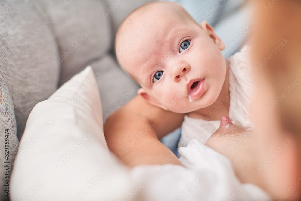 Happy young Mom breastfeeding child with breast milk. Mother hugging her baby. Happy young Mom breastfeeding child with breast milk. Mother hugging her baby.
