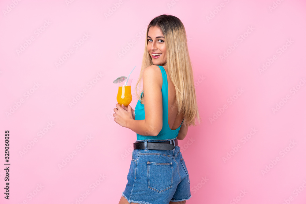 Young blonde Uruguayan woman in swimsuit in summer holidays over isolated pink background Young blonde Uruguayan woman in swimsuit in summer holidays over isolated pink background