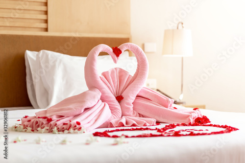 Fototapeta Naklejka Na Ścianę i Meble -  Two towel swans shaped on the bed in wedding ceremony day, Honey moon bed