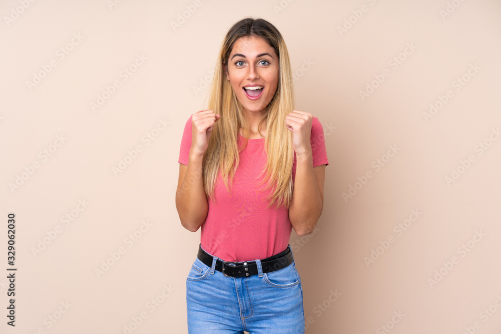 Young Uruguayan woman over isolated background celebrating a victory in winner position Young Uruguayan woman over isolated background celebrating a victory in winner position