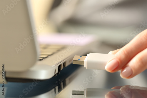 Woman connecting usb flash drive on a laptop photo