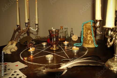 Fotografie candles are lit in a dark room on a round table, in silver candelabra, fortune-t
