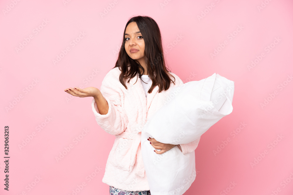 Young woman in pajamas isolated on pink background unhappy for not understand something Young woman in pajamas isolated on pink background unhappy for not understand something