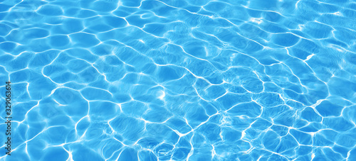 Water background  ripple and flow with waves. Summer blue swiming pool pattern. Sea  ocean surface. Overhead top view with place for text. Panoramic banner