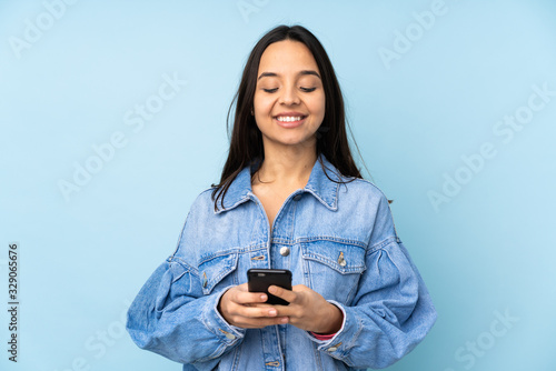 Young woman with a mobile over isolated background