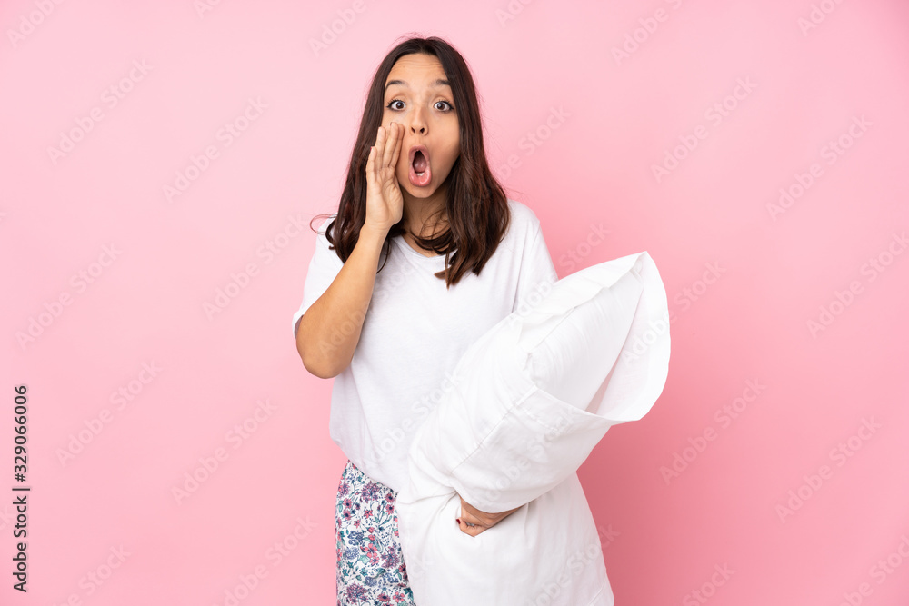 Young woman in pajamas isolated on pink background shouting and announcing something Young woman in pajamas isolated on pink background shouting and announcing something
