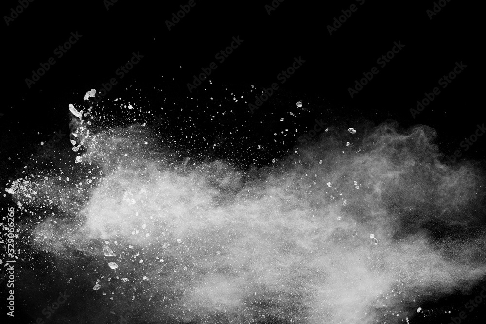 White powder explosion isolated on black background.White dust particles splash.