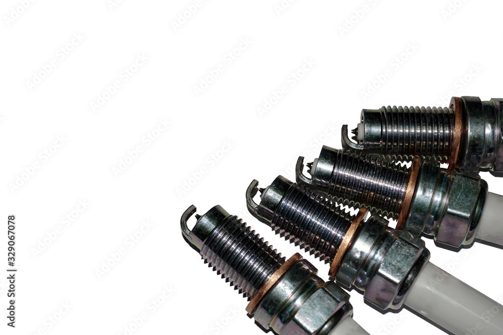 Spark plugs isolated on a white background. Service and repair of a modern car. Spare parts: sale and storage. Concept. Spark plugs isolated on a white background. Service and repair of a modern car. Spare parts: sale and storage. Concept.