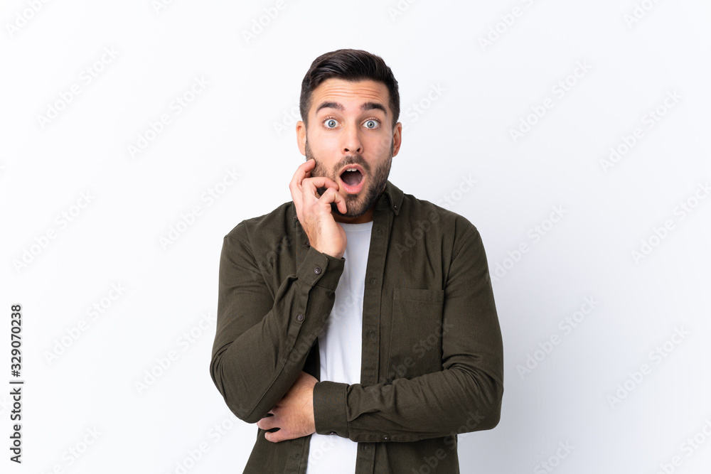 Young handsome man with beard over isolated white background surprised and shocked while looking right Young handsome man with beard over isolated white background surprised and shocked while looking right