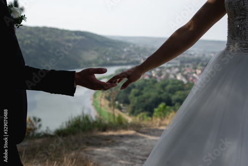 Closeup of brides holding hands on outdoor  free space. Bride and groom hugs. First wedding dance concept. Wedding details