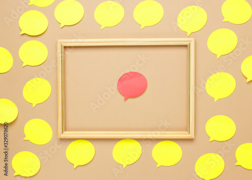 Empty yellow speech bubbles on beige background. Copy space. Abstract texture of small paper stickers. Different opinion concept