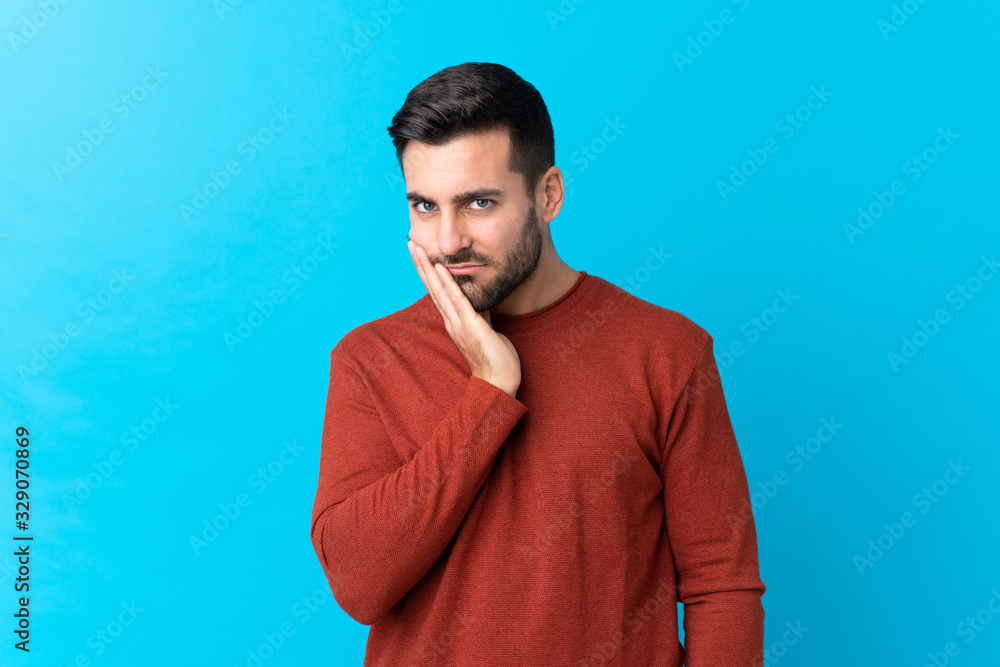 Young handsome man with beard over isolated blue background unhappy and frustrated Young handsome man with beard over isolated blue background unhappy and frustrated