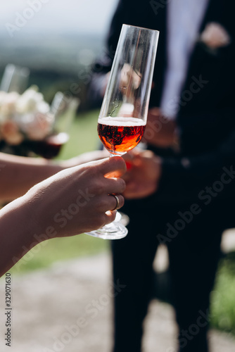 Vertical image of a group of people holding glasses with red champagne. Friends celebrate an important event.