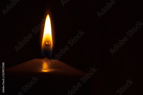 Close up of candle flame against black background for copy space