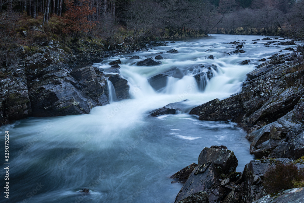 Long exposure shot of the waterfalls in Glen Orchy near Bridge of Orchy in the Argyll region of the highlands of Scotland during winter whilst the river is flowing fast from rainfall Long exposure shot of the waterfalls in Glen Orchy near Bridge of Orchy in the Argyll region of the highlands of Scotland during winter whilst the river is flowing fast from rainfall