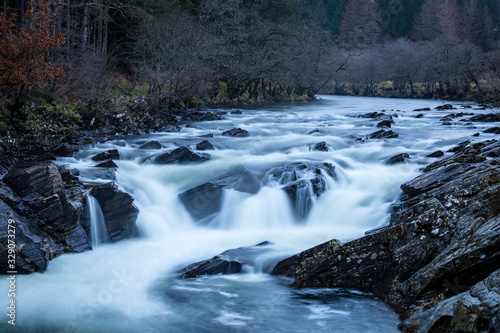 Long exposure shot of the waterfalls in Glen Orchy near Bridge of Orchy in the Argyll region of the highlands of Scotland during winter whilst the river is flowing fast from rainfall