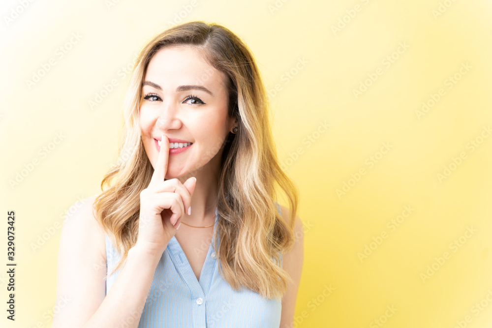 Fototapeta premium Gorgeous Smiling Woman Asking To Keep Silence
