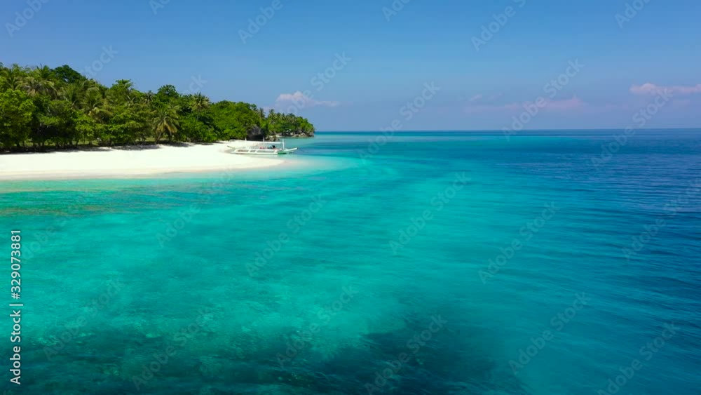 Tropical island with a white beach. Island with palm trees and white sand, top view. Summer and travel vacation concept. Mahaba Island, Philippines. Tranquil beach scene. Tropical island with a white beach. Island with palm trees and white sand, top view. Summer and travel vacation concept. Mahaba Island, Philippines. Tranquil beach scene.