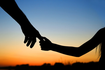 silhouette the parent holds the hand of a child